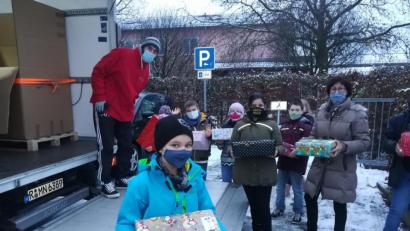 Bild: hmp
An ehrenamtliche Mitarbeiter von Humedica überreichen Schüler der Klasse 4c und Rektorin Eva Hampel die Weihnachtspäckchen.