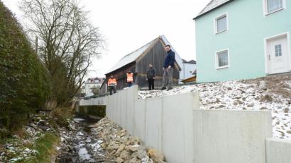 Bild: bey
Die Beseitigung der Straßenschäden in der Ringstraße machte die Errichtung einer neuen Böschungsbefestigung zum Mühlbach hin notwendig. Über die erfolgreiche abgeschlossene Maßnahme freuten sich Bauhofleiter Stephan Glossner, Michael Kraus, Firma Georg Kraus, Mantel, Geschäftsleiter Michael Gräf und Bürgermeister Sebastian Hartl (von links).