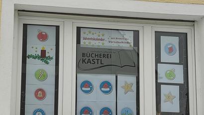 Bild: rpp
Das Bild zeigt eines der Fenster der Bücherei Kastl und einen Teil des Adventskalenders. Das erste Türchen wurde bereits geöffnet und dahinter kam eine sehr schöne Collage einer glitzernden Kerze am Zweig zum Vorschein .