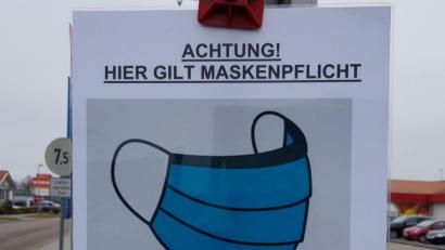Symbolbild: mp
Ein Schild auf einem Parkplatz weist auf die Maskenpflicht hin.