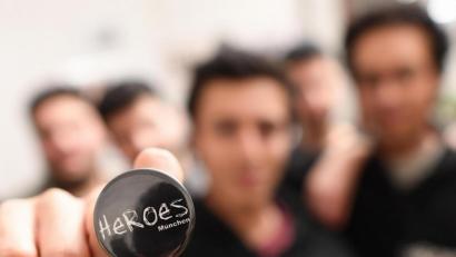 Archivbild: Angelika Warmuth
Ein Mitglied der "HEROES München" hält ihr Logo in die Kamera. HEROES ist ein Projekt für Gleichberechtigung, in dem sich junge Männer aus anderen Kulturen gegen die Unterdrückung im Namen der Ehre und für die Gleichberechtigung und Gleichstellung von Frauen und Männern engagieren.