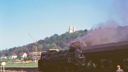 Bild: Sammlung Johannes Wiemann
Unterhalb der Wallfahrtskirche auf dem Schwandorfer Kreuzberg ist im Sommer 1972 eine Lok mit Rangierarbeiten beschäftigt. Dieses Motiv von Wilfried Sommer findet sich auf dem Juli-Blatt des neuen Eisenbahnkalenders.