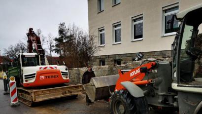 Bild: gz
Pfarrer Erwin Bauer macht sich ein Bild über die ersten Baumaßnahmen an der Steinmauer. Die Baufirma Spichtinger aus Schönsee rückt noch zwei Wochen vor Weihnachten mit Bagger und Raupe an.