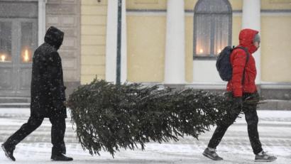 Bild: Heikki Saukkomaa/dpa
Im Schneetreiben tragen zwei Männer einen Christbaum nach Hause. Doch allzu oft kommt es in Deutschland nicht vor, dass es an Weihnachten schneit.