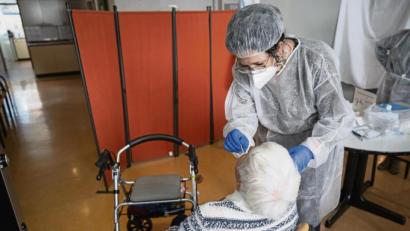 Bild: Sebastian Gollnow/dpa
Eine Altenpflegerin testet in einem Seniorenheim eine Bewohnerin.