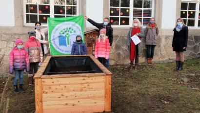 Bild: bsc
Mit Umweltschule-Flagge und Urkunde präsentierte sich coronabedingt eine kleine Delegation mit (hinten von links) Schulleiterin Inge Dick, Bürgermeister Oskar Schuster, Lehrerin Claudia Wölke, der Elternbeirat mit Hannelore Janko und Karin Gerolstein sowie (vorne) einige der Schüler des Arbeitskreises Umwelt vor einem der Projekte.