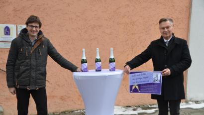 Bild: dob
Der evangelische Stadtpfarrer Dieter Schinke (rechts) wirbt mit Uli Münchmeier aus dem Kirchenvorstand für die Sekt-Aktion zugunsten der renovierungsbedürftigen Stadtkirche.