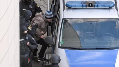 Bild: Hendrik Schmidt/dpa
Der angeklagte Stephan Balliet steigt in Begleitung von Justizpersonal nach dem Prozess in ein Fahrzeug der Justiz.