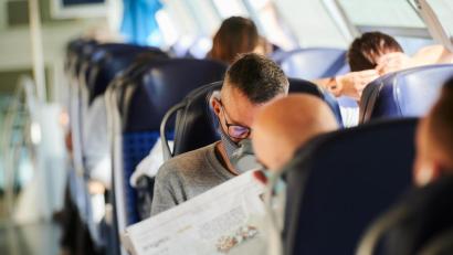 Bild: Annette Riedl/dpa
Reisende sitzen mit Nasen-Mund-Schutz in einem Zug.