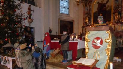Bild: amö
Der Erzähler liest die Weihnachtsgeschichte, während die Personen nur stumm mit Mund- und Nasenschutz dabei stehen.