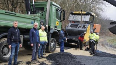 Bild: fppp
In der 90-Grad-Kurve ist Handarbeit angesagt, auf der Geraden kommt wieder der Fertiger zum Einsatz. Christian Frohmader und Stefan Kirsch vom Sachgebiet Tiefbau besichtigen den Fortgang der Asphaltierungsarbeiten zusammen mit Bauleiter Gerald Specht von der Firma Hans Fröber (von links).