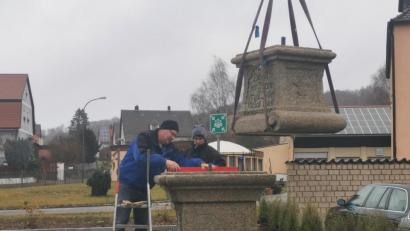 Bild: cog
Am Kranhaken hängt der obere Teil des Sockels, der untere steht schon fest. Bald kann die Sandsteinfigur des Heiligen Johannes von Nepomuk heimkehren.