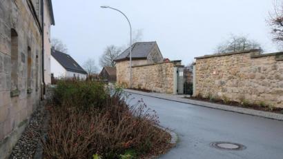Bild: do
Gemeinde- und Pfarrgemeinderätin Anneliese Weber wünscht sich anstelle der Grünfläche (links) auf Höhe des Eingangs zur Expositurkirche St. Johannes Evangelist einen Behindertenparkplatz .