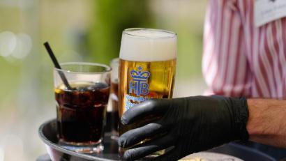 Bild: Sebastian Willnow/dpa
Ein Kellner arbeitet in einem Biergarten und trägt dabei Gummihandschuhe. Mit den Einschränkungen in der Corona-Krise ist die Zahl geringfügig Beschäftigter deutlich zurückgegangen. Minijobs sind oft die ersten, die in der Krise wegbrechen.