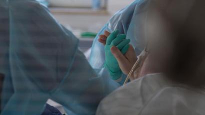 Bild: Henning Kaiser/dpa
Eine Ärztin hält in einer Intensivstation die Hand eines Coronapatienten.