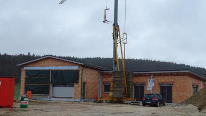 Bild: Houschka
Durch einen von der Gemeinde besonders hervorgehobenen Eigenanteil an Arbeiten, die von Feuerwehrangehörigen geleistet wurden, ist das neue Gerätehaus der FFW Högling unterdessen in seinen Konturen klar erkennbar. Der Rohbau ist durch die Dachaufsetzung winterfest gemacht worden.