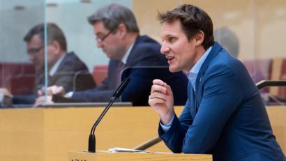 Bild: Sven Hoppe/dpa
Ludwig Hartmann, Fraktionsvorsitzender von Bündnis 90/Die Grünen im bayerischen Landtag, spricht während einer Sondersitzung. Im Hintergrund verfolgt Markus Söder (CSU), Ministerpräsident von Bayern, die Rede.