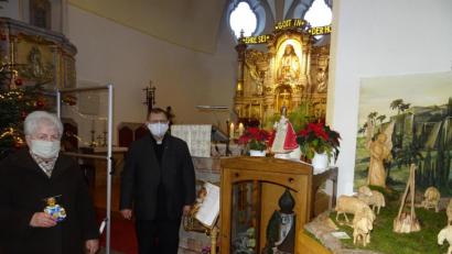 Bild: apr
Margarete Schulda und Pfarrer Robert Ploß bei der Nachbildung des "Prager Jesuleins" in der Pfarrkirche Herz Jesu in Pechbrunn.