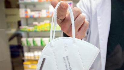 Bild: Friso Gentsch
Ein Apotheker hält eine FFP2-Maske an einem Finger. Foto: Friso Gentsch/dpa