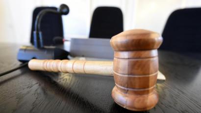 Bild: Uli Deck
Auf der Richterbank liegt am ein Richterhammer aus Holz. Foto: Uli Deck/dpa/Illustration/Archivbild