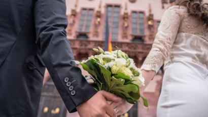 Bild: Frank Rumpenhorst/dpa
Ein Brautpaar steht nach der standesamtlichen Trauung auf dem Römerberg in Frankfurt.