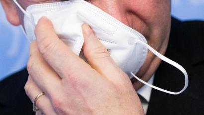 Symbolbild: Rolf Vennenbernd
Ein Mann nimmt seine FFP2-Maske ab.