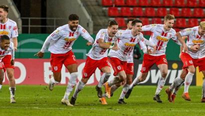 Bild: Armin Weigel^/dpa
Der Moment des größten Pokalerfolgs in der Vereinsgeschichte des SSV Jahn Regensburg: Max Besuschkow hatte soeben den entscheidenden Elfmeter gegen den 1. FC Köln verwandelt, seine Mitspieler sprinteten ihm anschließend alle entgegen.