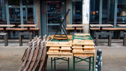 Symbolbild: Daniel Bockwoldt/dpa
Zusammengestellte Tische und aufgestapelte Stühle stehen vor einem geschlossenen Café in Hamburg.
