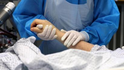 Bild: Bernd Wüstneck
Im Infektionszimmer für Covid-19-Patienten hält die Mitarbeiterin einer Intensivstation die Hand eines Patienten. Foto: Bernd Wüstneck/dpa-Zentralbild/dpa/Archivbild