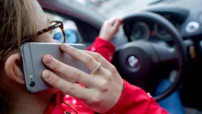 Bild: Hauke-Christian Dittrich/dpa
Eine junge Frau telefoniert am Steuer ihres Wagens (Symbolbild): In Amberg hat das eine Frau sogar zweimal hintereinander getan – und wurde beide Male von der Polizei erwischt.