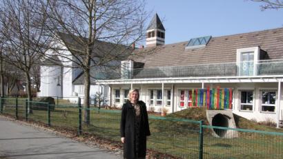 Bild: kro
Pfarrerin Dr. Stefanie Schön vor der evangelischen Erlöserkirche und dem evangelischen Kindergarten in Tirschenreuth.