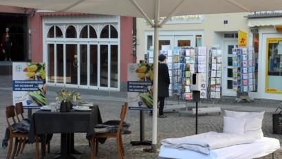 Bild: Wolfgang Steinbacher
Stiller Protest auf dem Marktplatz: Ein leerer Tisch und ein verwaistes Bett sollen auf die Situation der Gastronomie und Hotellerie aufmerksam machen.