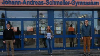 Bild: Tine Fiala/exb
Annika Kleierl (Mitte) zeigt das Bild, nachdem ihr Schulleiter und Lehrer gratuliert hatten.