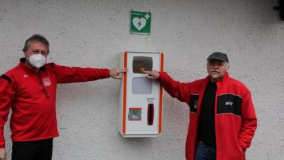 Bild: kro
Stolz zeigen Bernd Aßmann (links) und Gerhard Greger auf den am TSV-Sportheim angebrachten Defibrillator. Die Investitionskosten beziffern sie mit 8000 Euro.