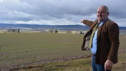 Bild: jr
Von der Stelle am Waldrand oberhalb von Leonberg aus, an der die kleine Aussichtsplattform entstehen soll, deutet Bürgermeister Johann Burger in die Ferne. Bei schönem Wetter könne man weit über die Umgebung hinaus blicken, schwärmt er.