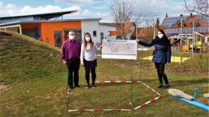 Bild: jml
Stefan Kurz und Tochter Susanne Scheuerer übergeben an Leiterin Marion Eitel (rechts) einen Scheck über 500 Euro als Grundstock. Damit soll für den Kindergarten Arche Noach im mit Trassierband abgesteckten Bereich ein neues Klettergerät gekauft werden