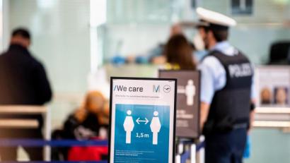 Archivbild:  Matthias Balk/dpa
Ein Polizist beobachtet die Grenzkontrollen am Flughafen München. Flüge in den Süden, etwa nach Mallorca, sind wieder möglich. Dafür ist die Öffnung von Hotels und Gastronomie hierzulande nach wie vor nicht in Sicht.