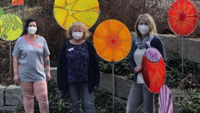 Bild: hka
Glaskunst im Garten des Caritas-Hauses St. Barbara. Davor stehen (von links) Simone Kronhöfer, Pflegehelferin und Vorsitzende der Mitarbeitervertretung, Christine König aus der Verwaltung und Heimleiterin Marina Fink, auch sie sind wahre "Corona-Helden".