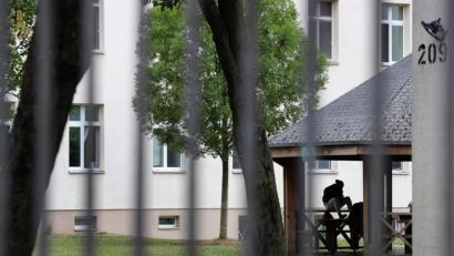 Symbolbild: Karl-Josef Hildenbrand/dpa
Ein Asylsuchender sitzt vor einem Wohnblock im Ankerzentrum Schweinfurt.