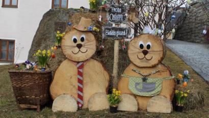 Bild: soj
Herrlich geschmückt haben einige Helfer den Aufgang zur Kirche mit einem Osterhasenehepaar und Blumen.