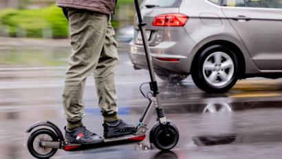 Bild: Christoph Soeder/dpa
Ein Mann fährt mit einem E-Scooter auf der Straße.