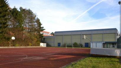 Bild: as
Direkt neben der alten Dreifachhalle am Gymnasium ist der Neubau auf dem ausrangierten Allwetterplatz (im Vordergrund) geplant. Nach der enormen Kostensteigerung soll nun noch einmal die Möglichkeit einer Sanierung bedacht werden.