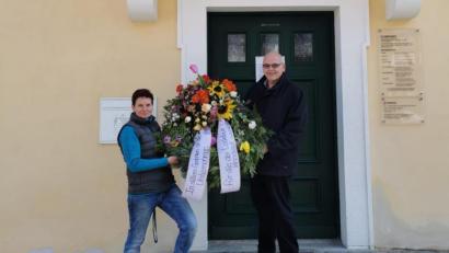Bild: Andrea Burger/exb
Andrea Burger bei der symbolischen Übergabe des Trauerkranzes an Bürgermeister Klaus Meyer vorm Rathaus Bad Neualbenreuth.