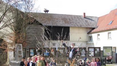 Bild: sei
Die Kinder der Blauen Gruppe des Kinderhauses trafen sich mit Bürgermeister Richard Kammerer und hingen noch weitere, mit Glitzersteinchen verzierte Eier an den Strauch. Kammerer dankte vor allem dem Unbekannten, der einen Osterhasen zum Strauch gestellt hat.