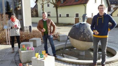 Bild: fsb
Organisatorin Doris Troglauer und Teamführer Konrad Braun vom Jugendgremium der Gemeinde präsentieren mit Bürgermeister Dietmar Schaller (von links) am Ortsbrunnen ihre Osteridee.