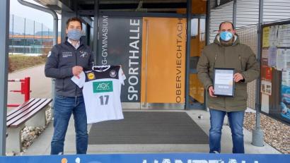 Bild: lg
Sportlehrer Michael Teplitzky (links) zeigt das T-Shirt mit den Unterschriften der Herren-Nationalmannschaft. Handballchef Michael Lang präsentiert die Urkunde, mit der der Deutsche Handballbund das innovative und kreative Vereinsengagement würdigt.