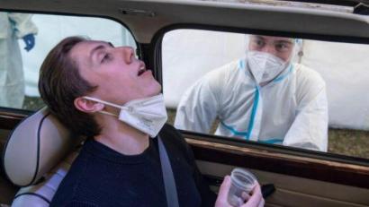 Symbolbild: Boris Roessler/dpa
Zu Demonstrationszwecken zeigt ein Freiwilliger die Funktionsweise eines PCR-Tests mit Gurgeln.