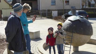 Bild: fsb
Laura und Max haben am Dorfbrunnen das Täfelchen 15 entdeckt und lassen sich für den Wettbewerb fotografieren.