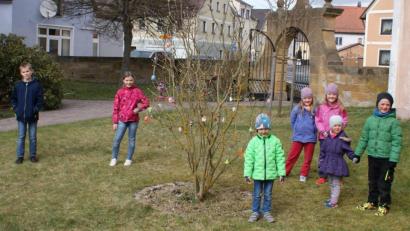 Bild: sei
Die Kinder schmückten den Fliederstrauch im evangelischen Kirchgarten und r freuten sich nach einer aufregenden Suche im Kirchgarten über Naschereien.
