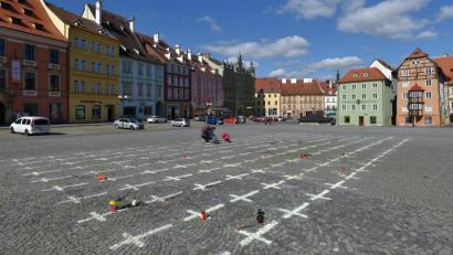 Bild: Kubeš Slavomír/CTK/dpa
Kerzen und Blumen liegen neben weißen Kreuzen, die auf das Pflaster eines Platzes in Eger gemalt wurden. Die Kreuze erinnern an die Opfer der Corona-Pandemie.